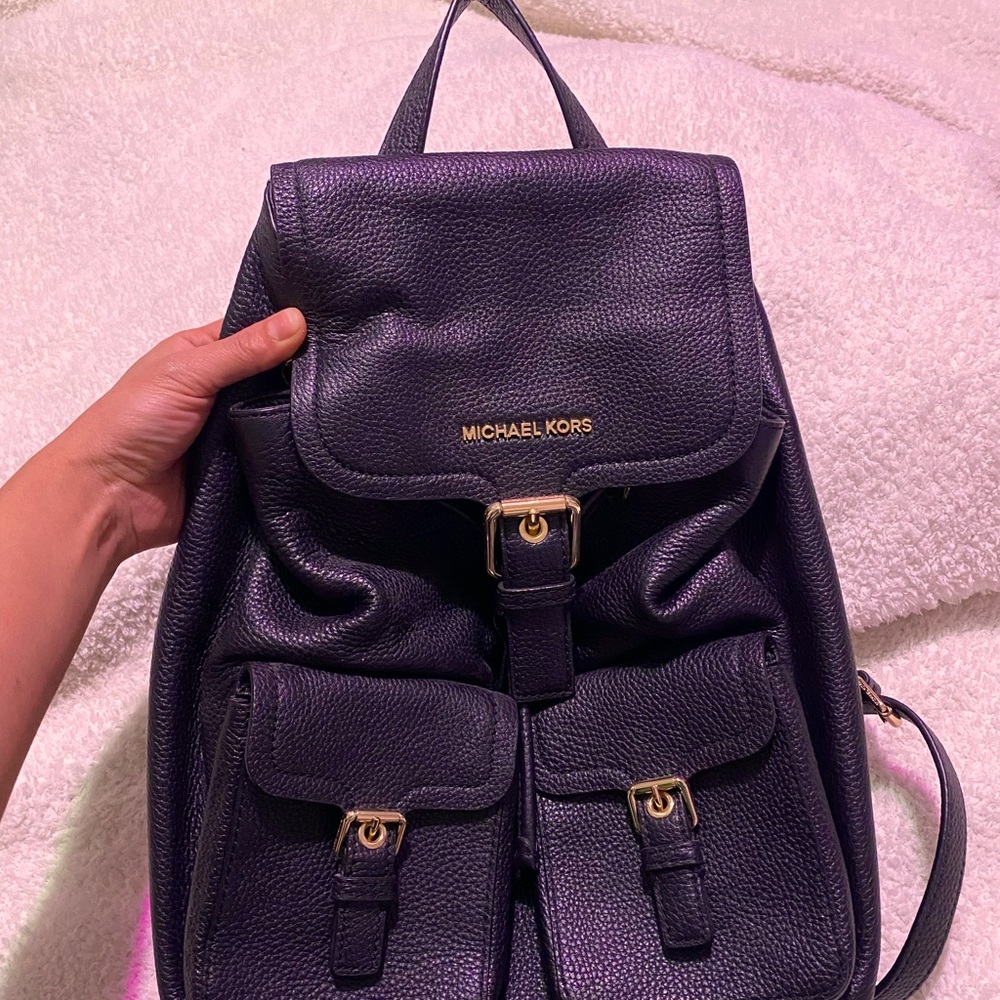 Black pebble leather Michael Kors Susie flap backpack.